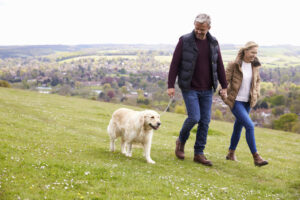 A couple walking their dog. 