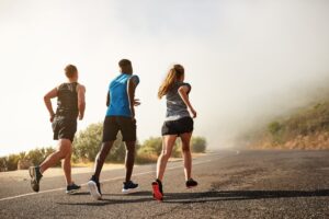 Three people running outdoors.