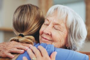 A senior woman hugging a caregiver.