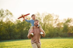 A father with a child sitting on his shoulders.