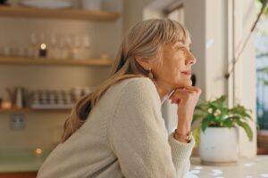 A woman looking out of the window at home.