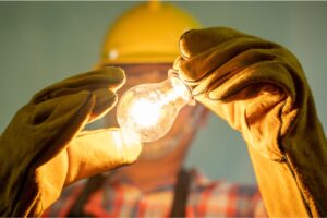 An electrician holding a light bulb.