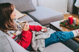A woman relaxing wearing a Christmas jumper.