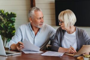 A mature couple talking and looking at paperwork together