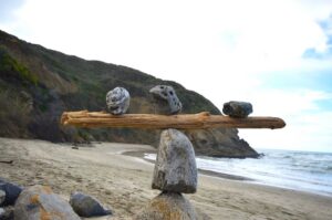 Rocks balancing on log on top of another rock
